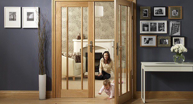 Women watches baby crawl through double doors