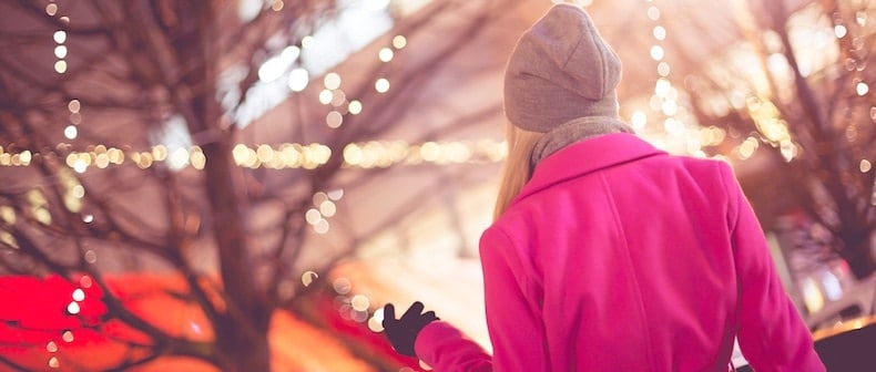 Person looking toward festive lights in trees