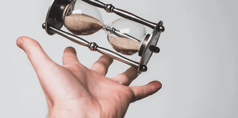 Hand reaching for an hourglass