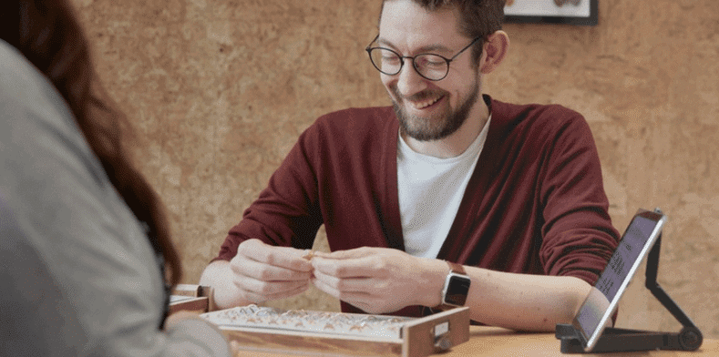 Man smiles whilst looking at rings in store