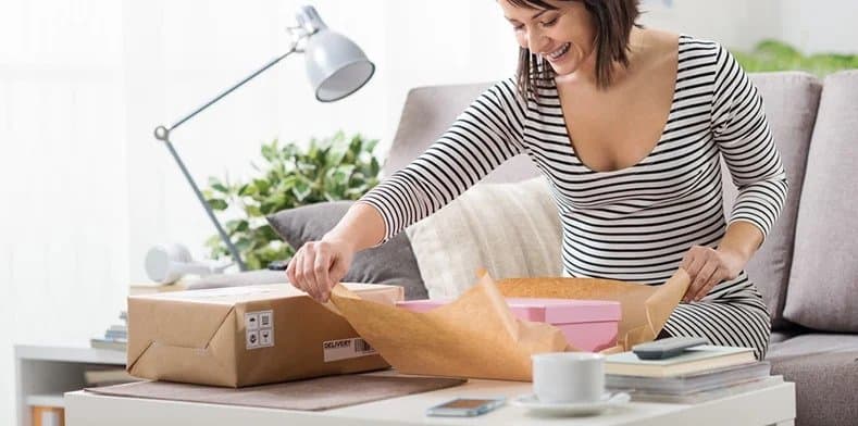 Person sat on sofa unwrapping gift