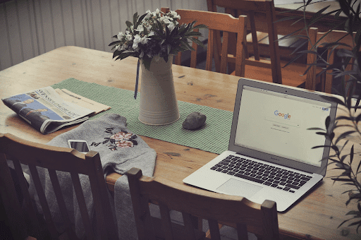 Laptop on a wooden table with plants