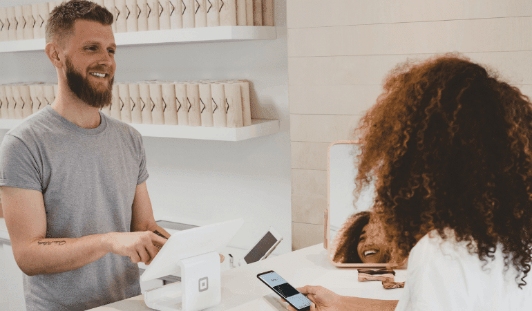 People at checkout, paying with mobile phone