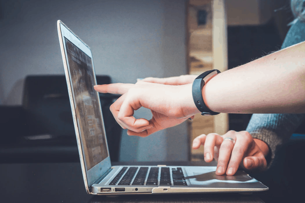 People pointing at laptop screen