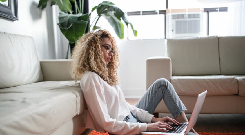 Woman blogs on laptop in bright and modern apartment