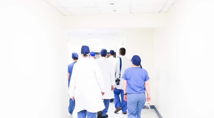 Medical staff walk down corridor