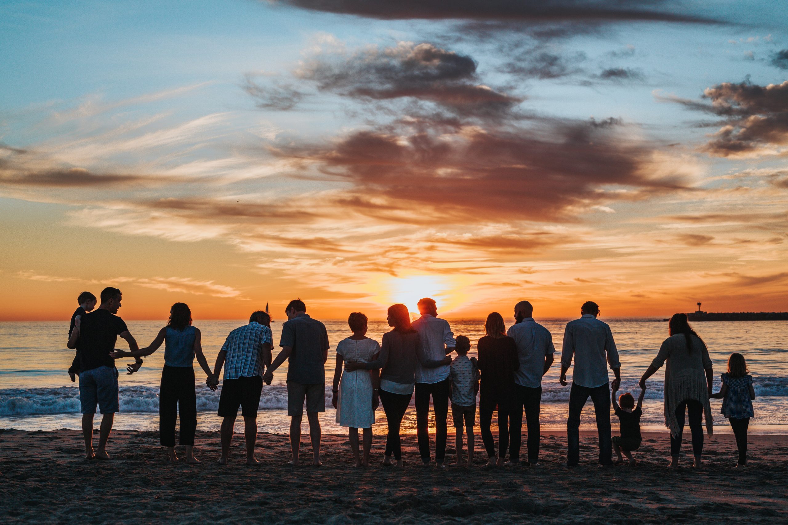 People on a beach looking toward the sunset