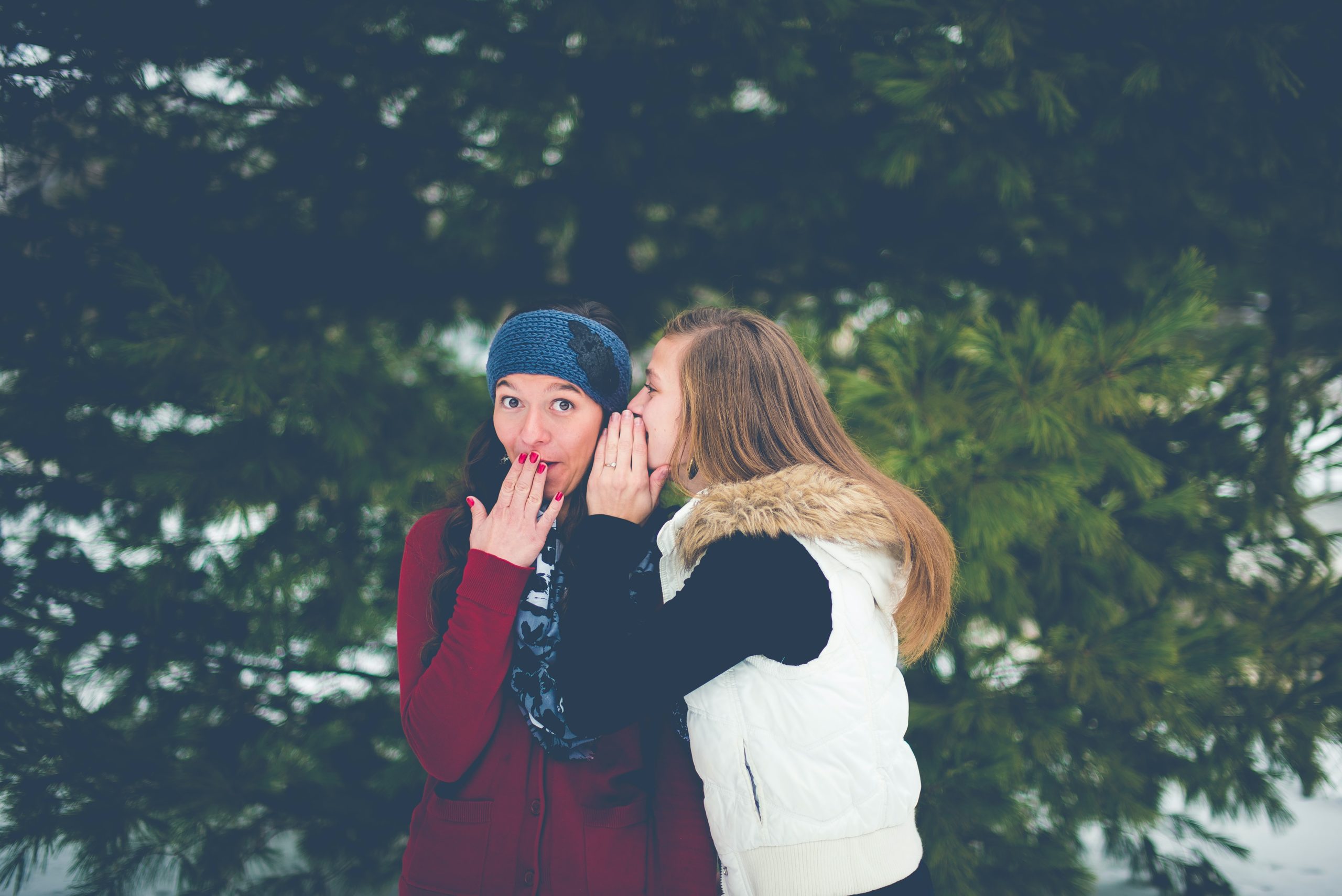 People in wintery scene whisper to each other