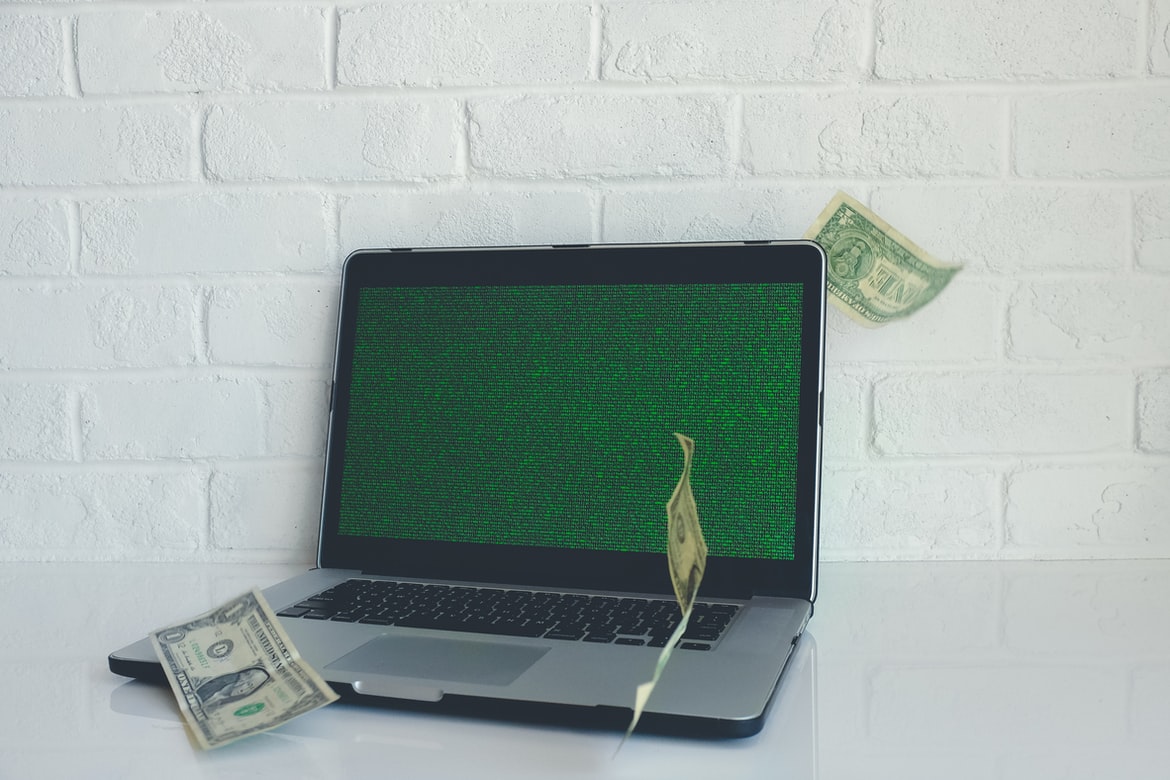 Laptop with dollars floating past