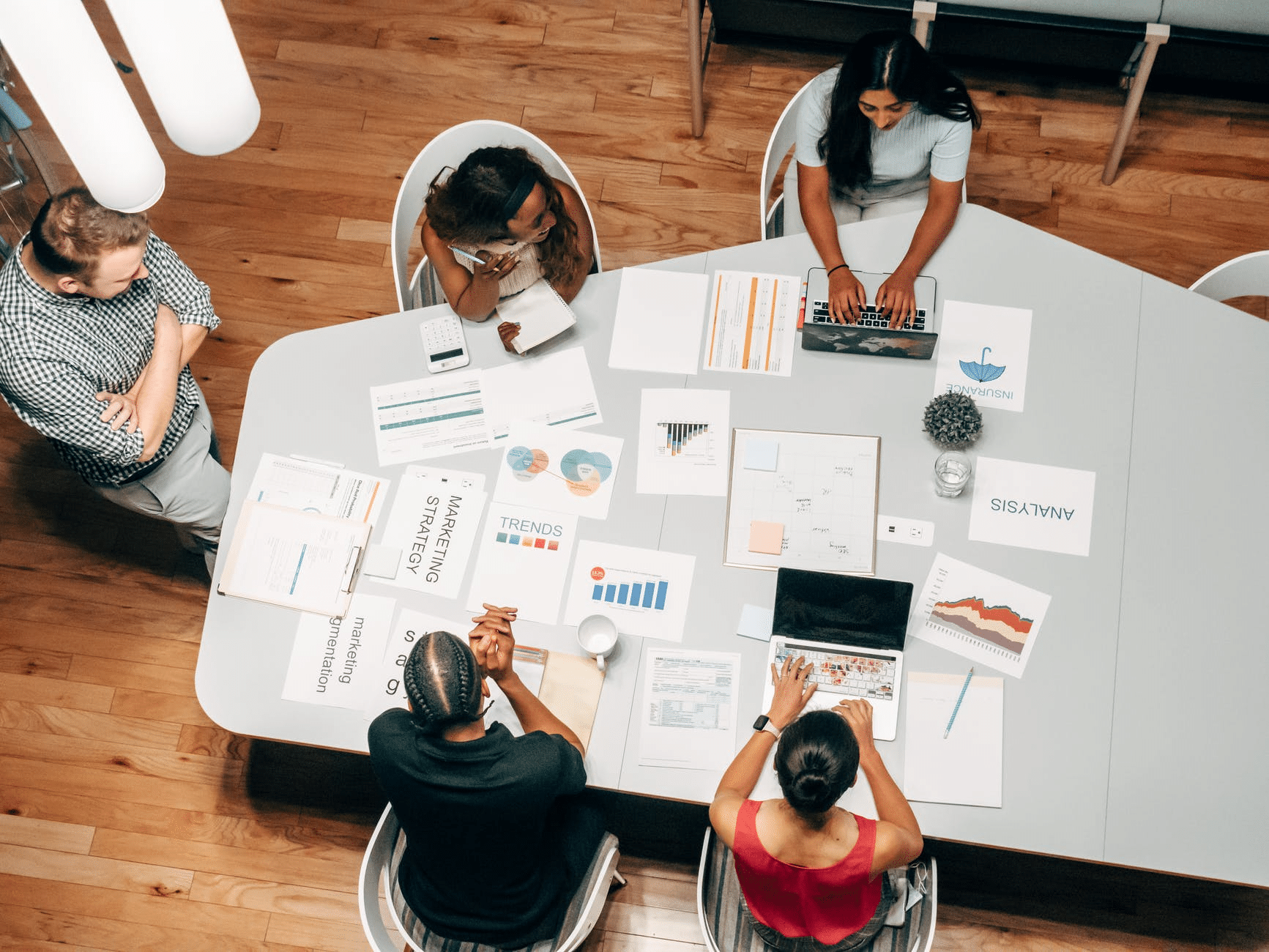 Overhead shot of people working around a large office desk