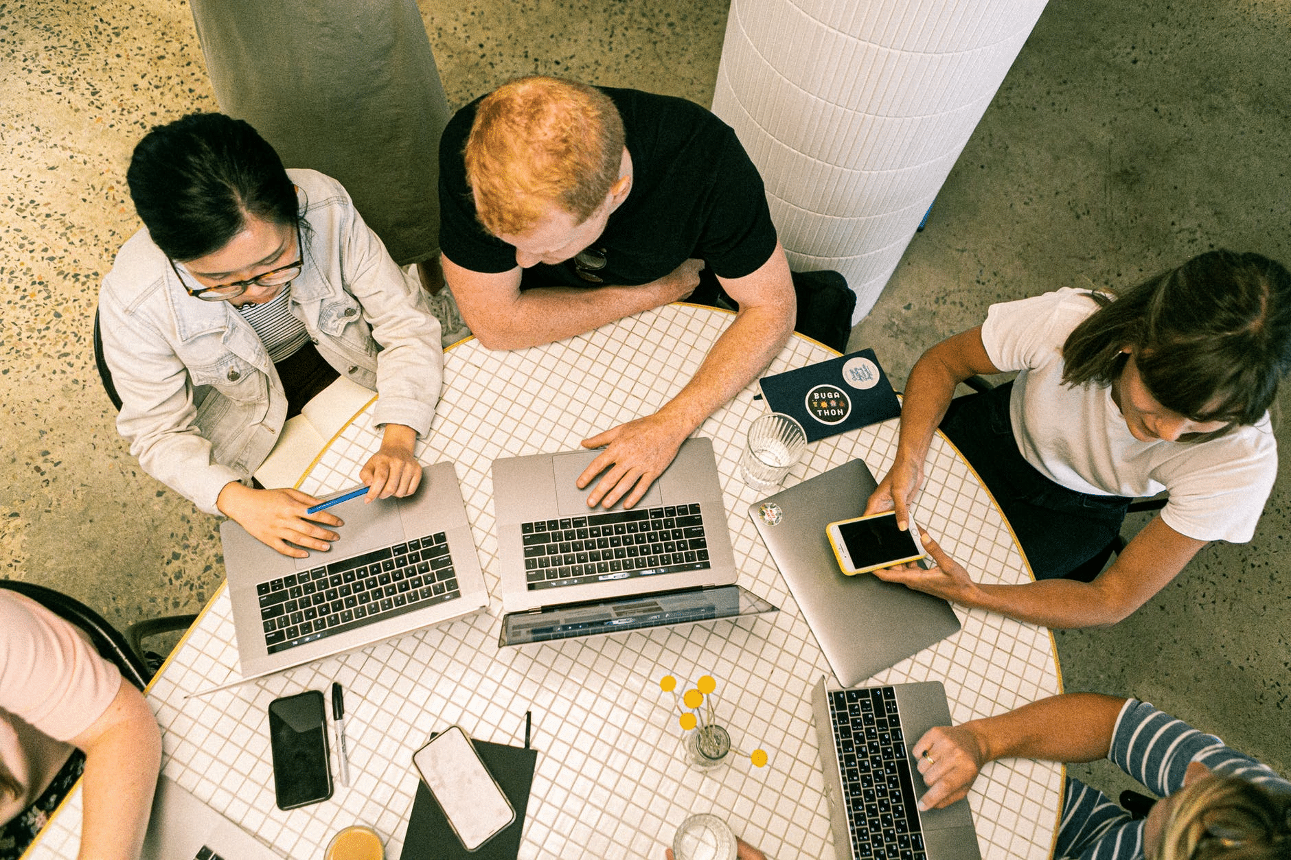 People at a meeting table with laptops