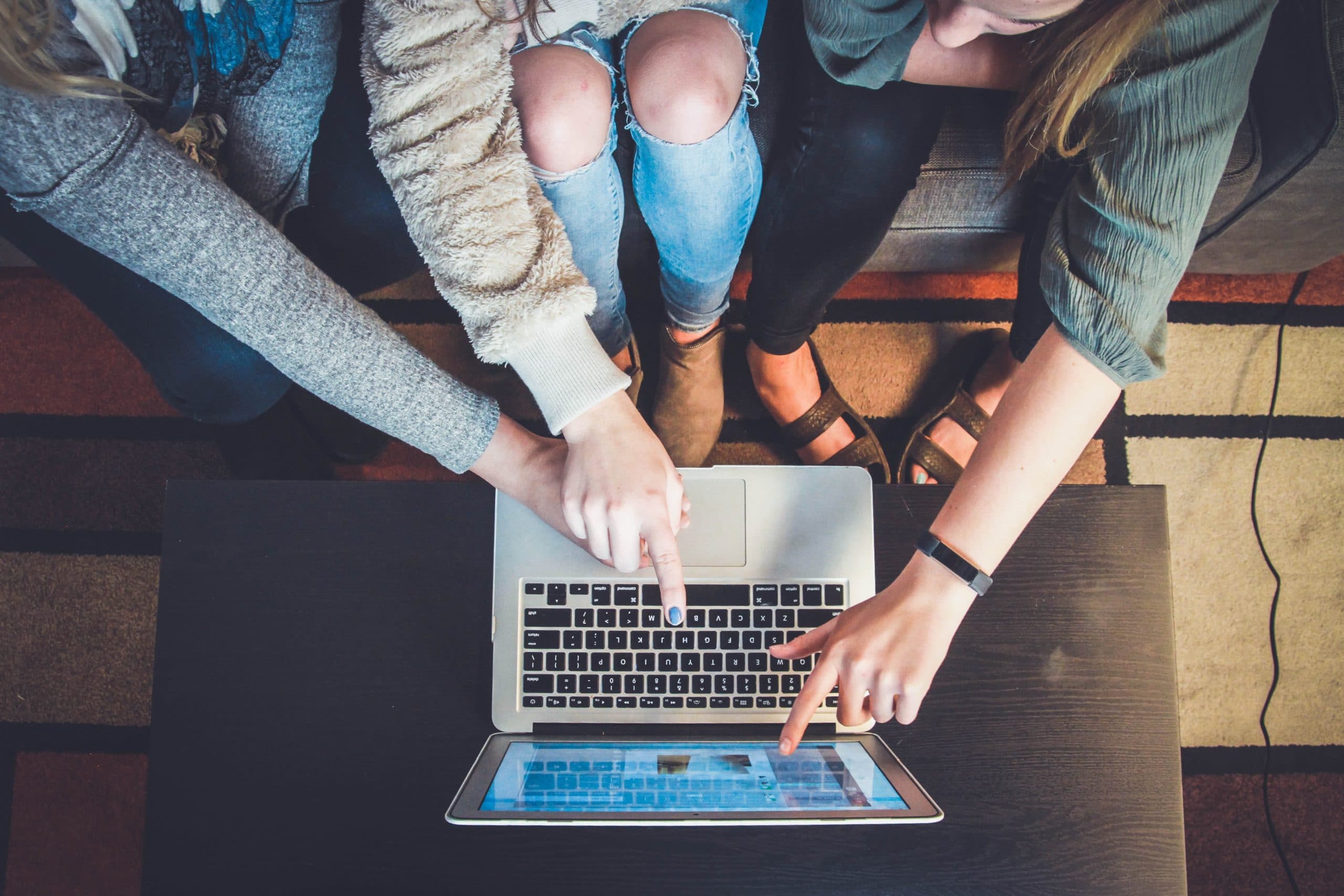 Aerial shot of people pointing at laptop screen