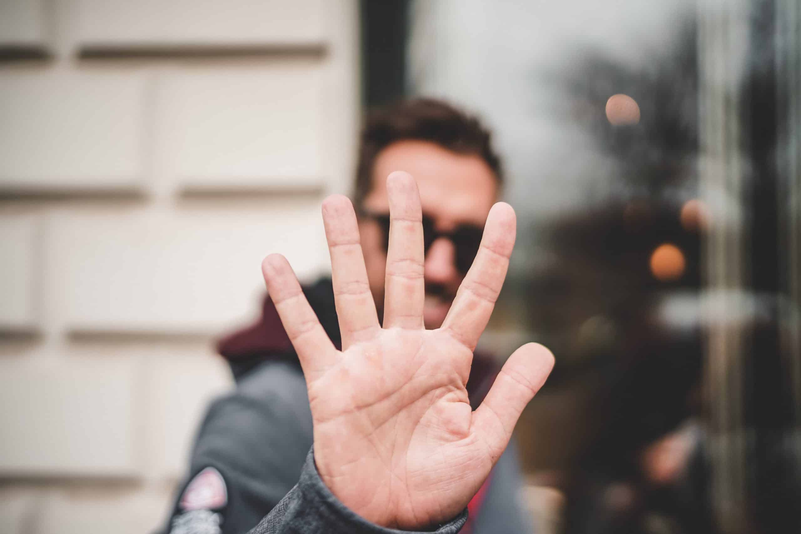 Person holds hand up to camera