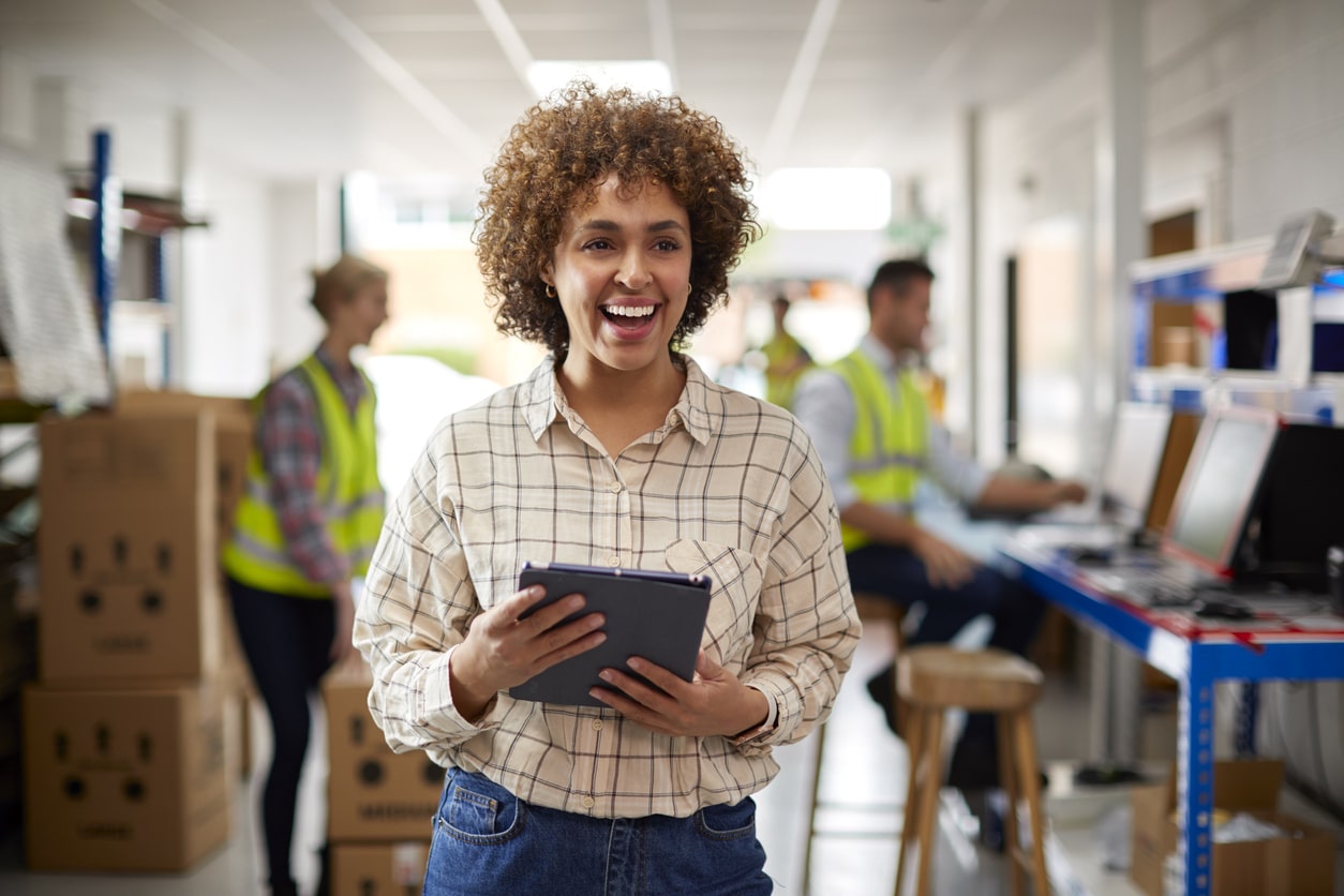 Person In Logistics Distribution Warehouse Using Digital Tablet