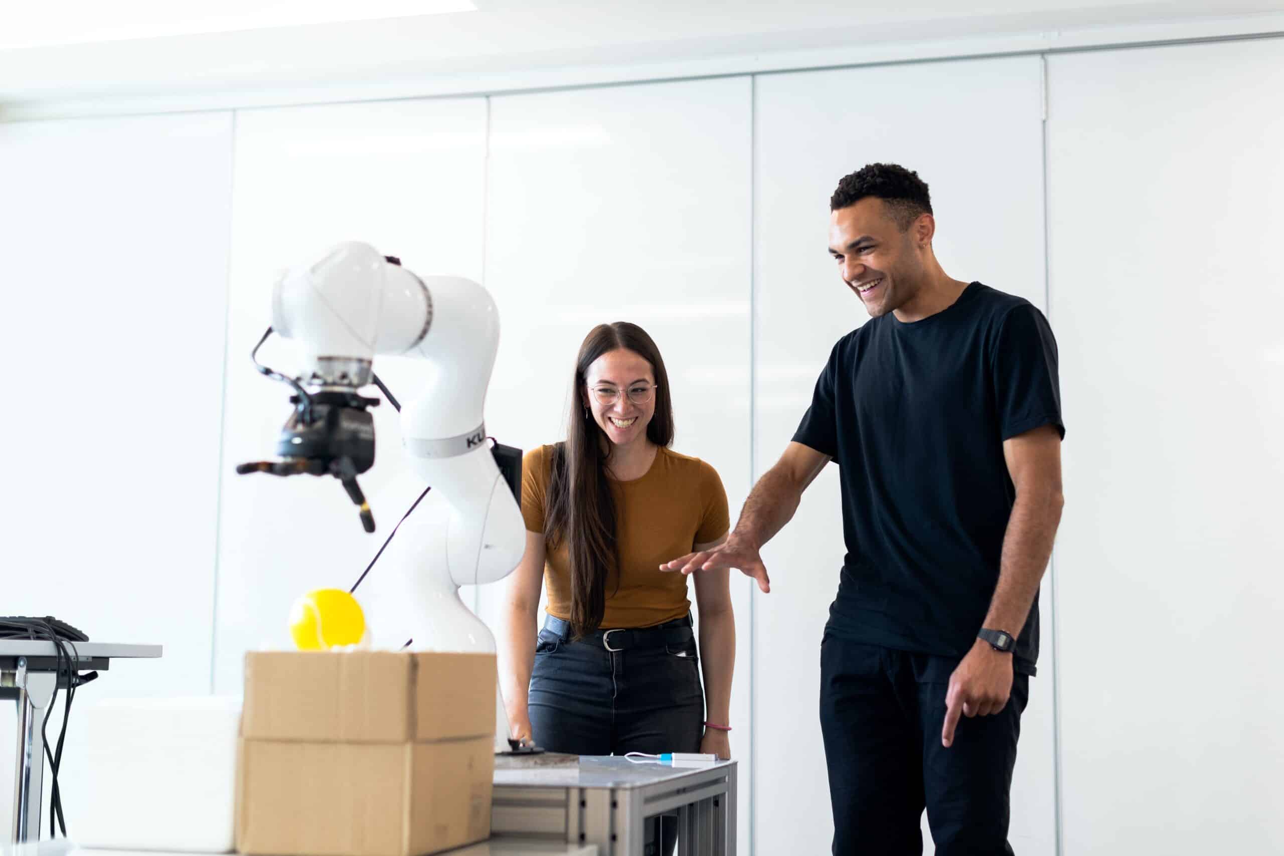 People smiling whilst using a robot arm