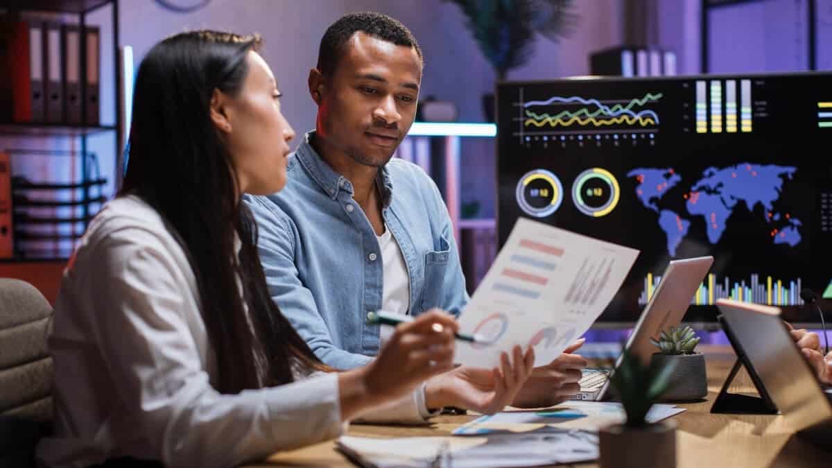 Finance professionals reviewing net working capital calculations using reports and digital dashboards